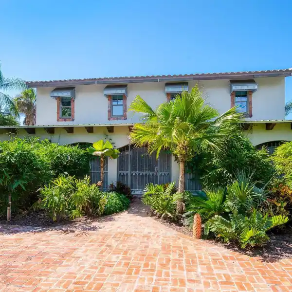 CAPTIVATING HOME HIDDEN BEHIND LUSH PLANTINGS