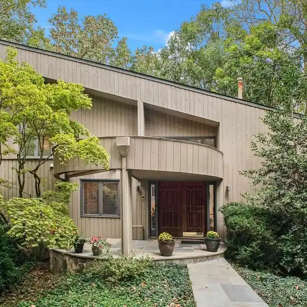 NESTLED AMONG MATURE TREES ON A BEAUTIFULLY LANDSCAPED CORNER LOT